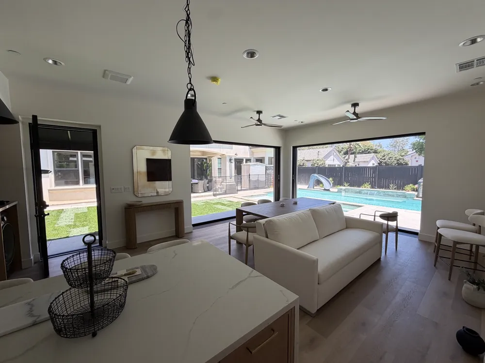Indoor-outdoor living space opening to a backyard pool