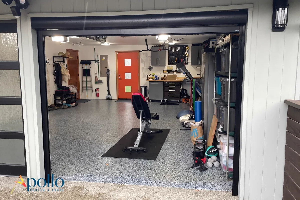 Garage gym behind a motorized retractable garage door screen — Apollo PowerScreens