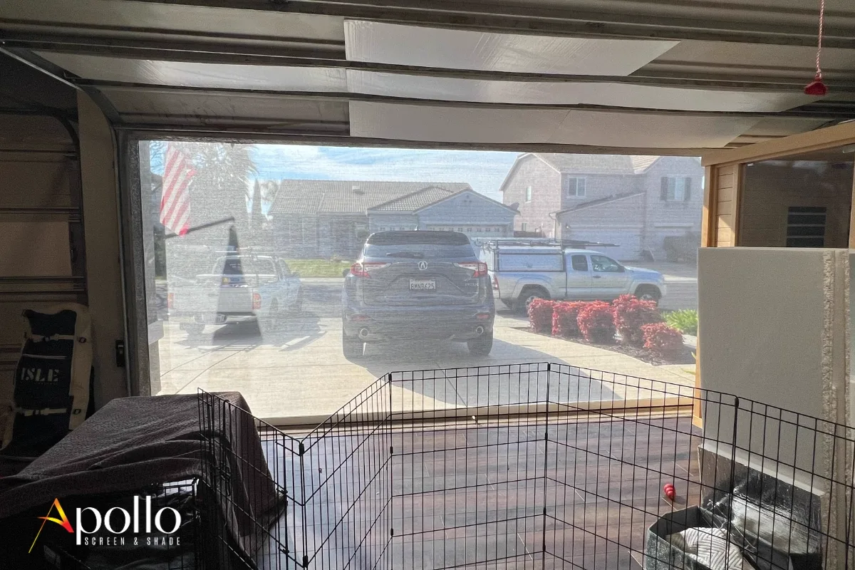 Looking out through a garage door screen from inside — pets stay in, bugs stay out